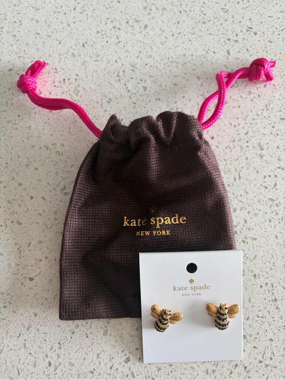 kate spade gold and black bee stud earrings with brown pouch and pink drawstring